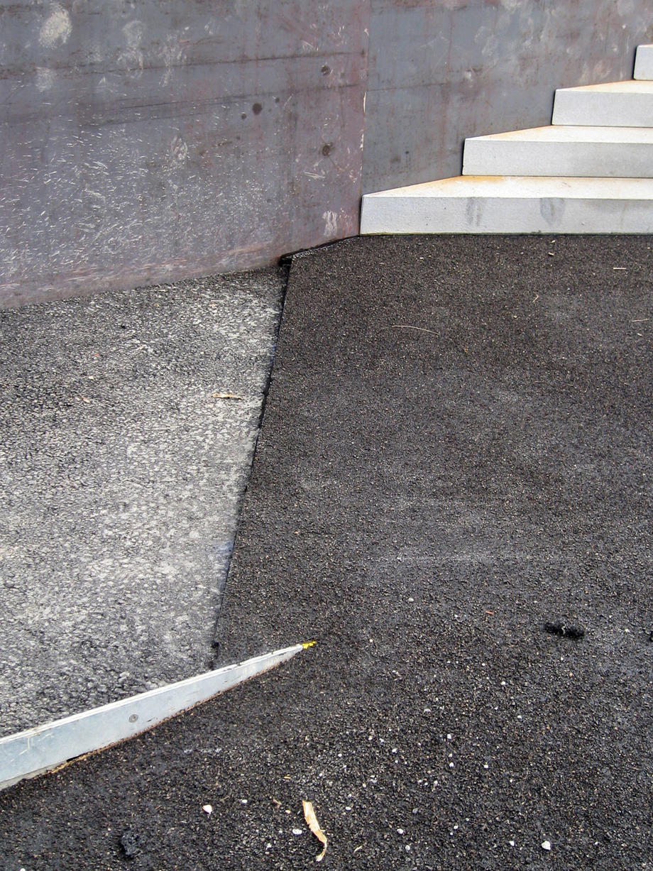 Belagsübergang Hochlast-Gussasphalt gestrahlt (Platzfläche) zu Walzasphalt (Rampe) vor Einbau der Deckschicht