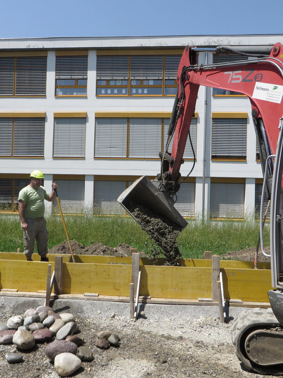 Einfüllen der Betonmischung - die ausgewählten Steine sind  im Vordergrund bereitgelegt